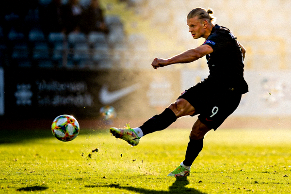 挪威前锋哈兰德标志性的强力射门动作，展现其惊人的力量与射术